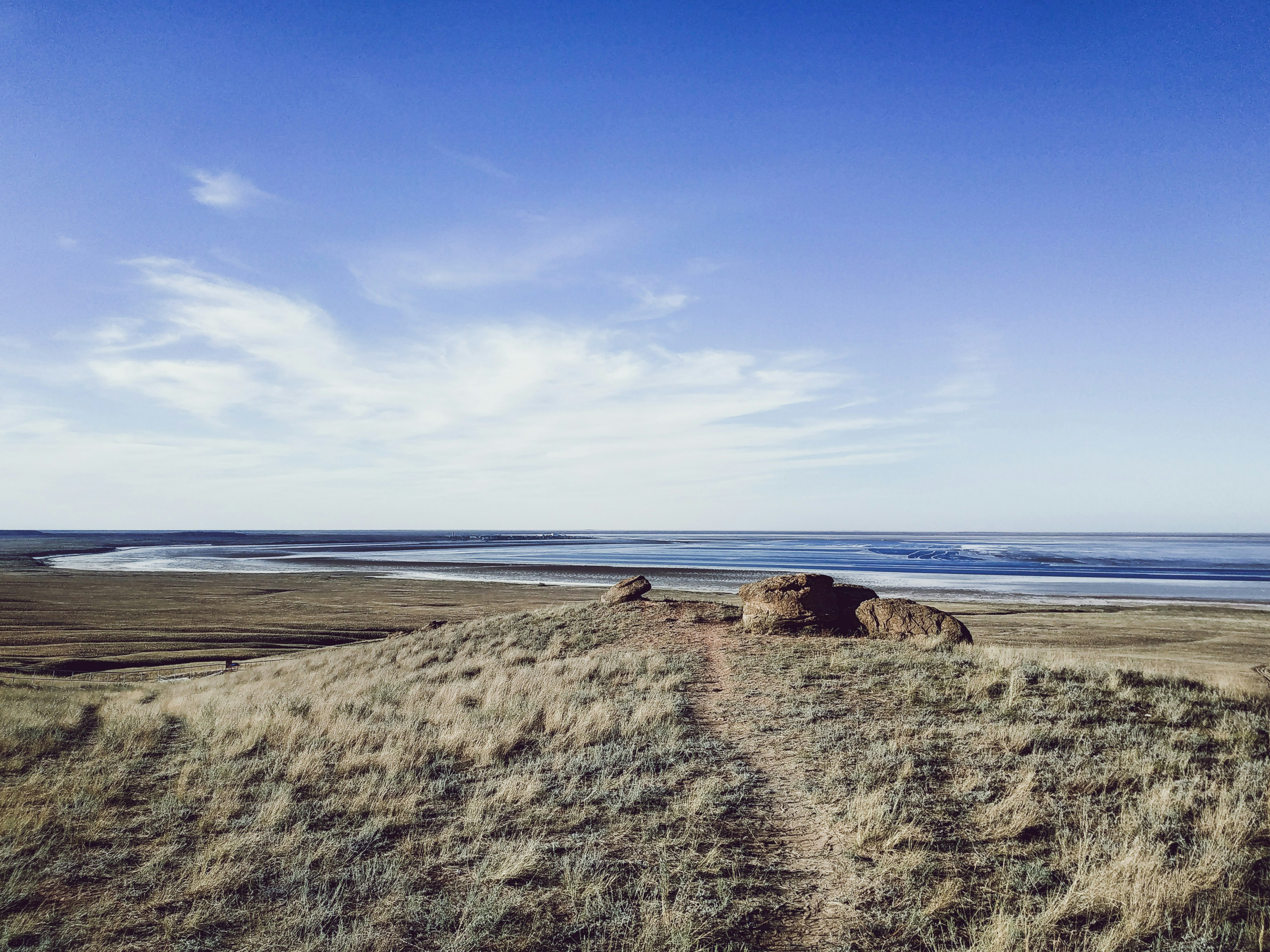 brown sand near body of water during daytime